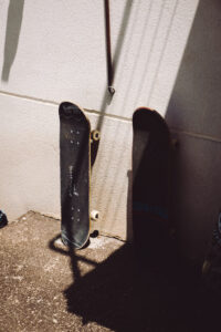 How to change your grip tape, two skateboards are standing in front of a wall.